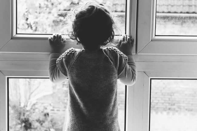 Kind stehen vor dem Fenster